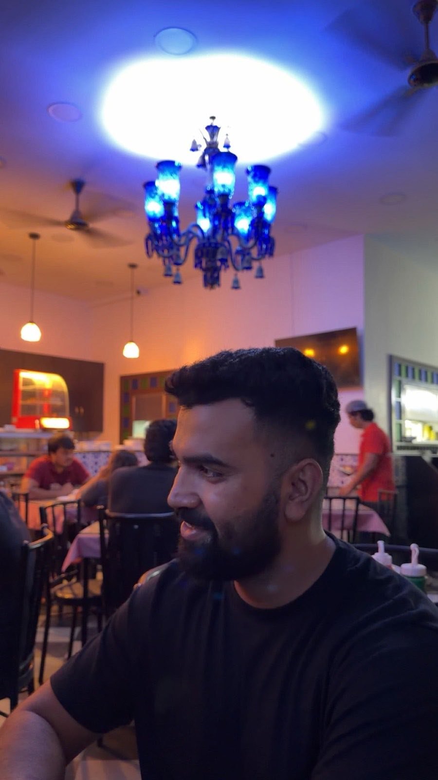 Rishav at a table under blue light